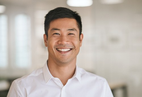 Man in white button-up shirt smiling