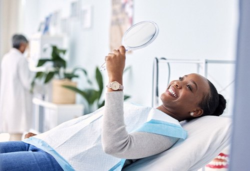 Woman smiling while looking at reflection in mirror
