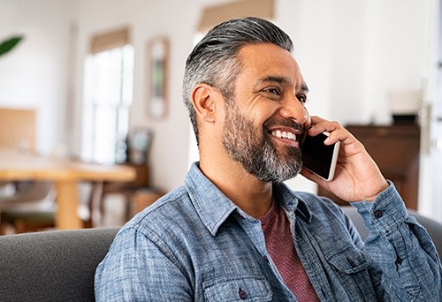 Farmington Hills patient speaking on phone after dentures