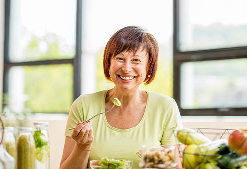 Farmington Hills patient eating healthy meal with dentures
