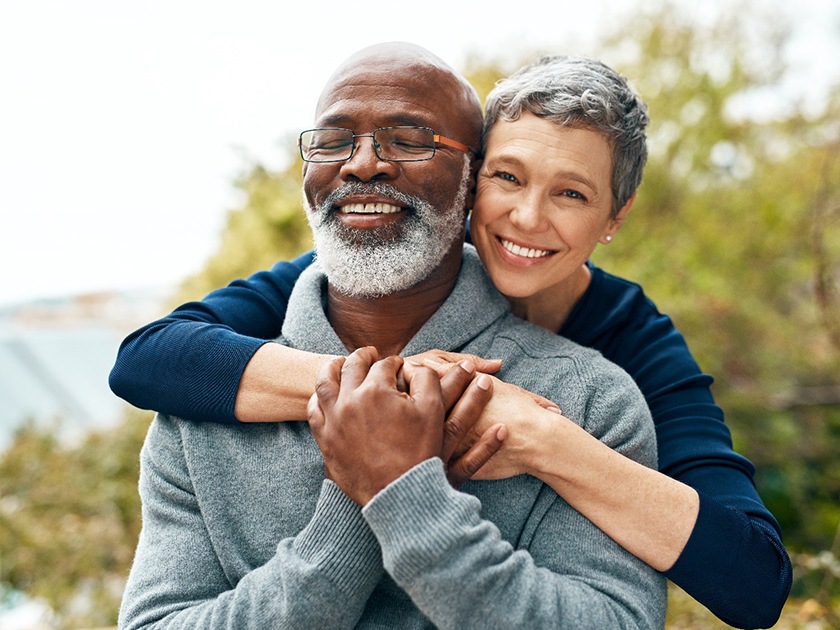 Man and woman outside hugging and smiling
