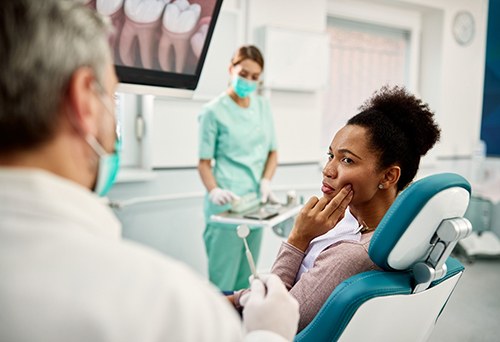 Patient with toothache looking at dentist in treatment chair