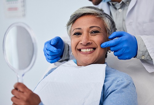 a patient admiring her cosmetic dental results 