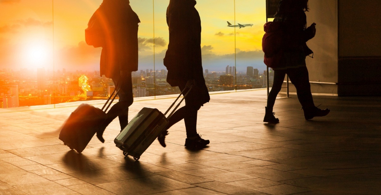 Three people walking through airport at sunset