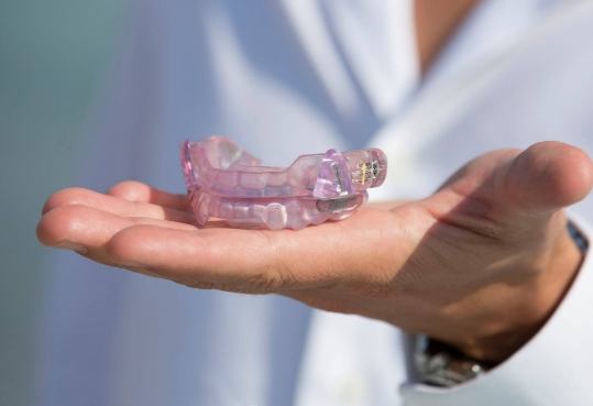 Dentist holding light purple dental trays