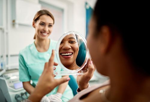 Patient smiling at reflection in treatment chair
