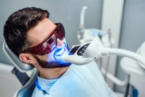 Man having teeth whitened at dentist's office.